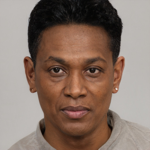 Joyful black adult male with short  black hair and brown eyes