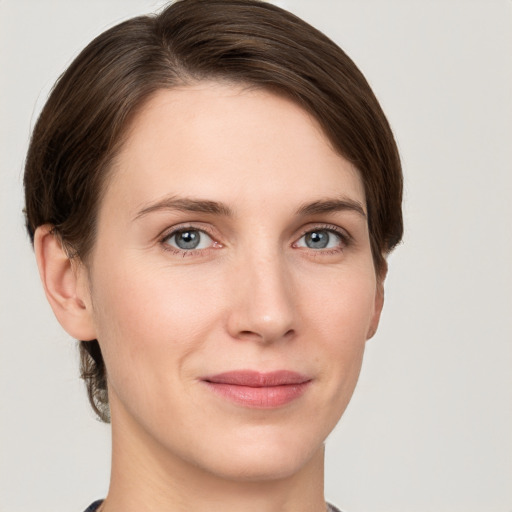 Joyful white young-adult female with short  brown hair and grey eyes