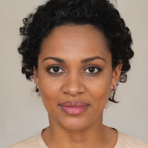Joyful black young-adult female with short  black hair and brown eyes
