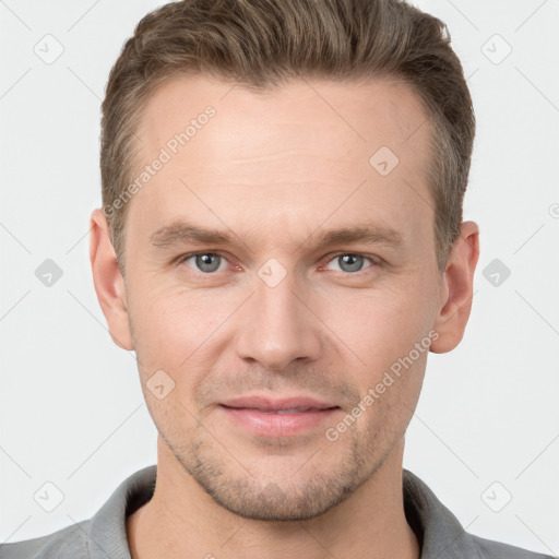 Joyful white young-adult male with short  brown hair and grey eyes