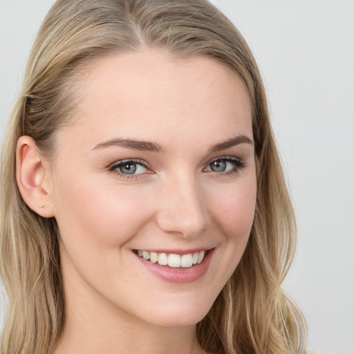 Joyful white young-adult female with long  brown hair and blue eyes