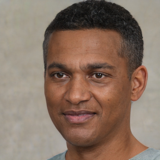 Joyful black adult male with short  black hair and brown eyes