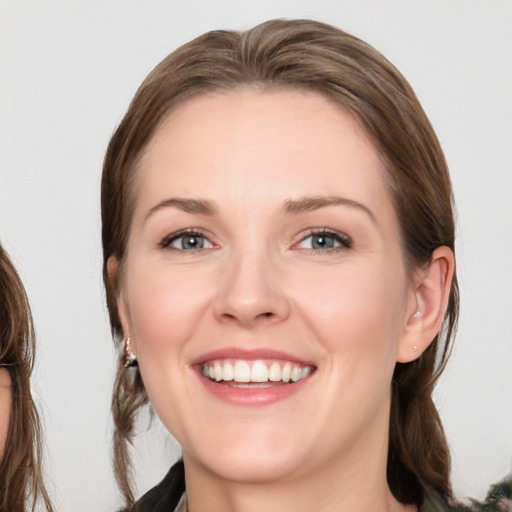 Joyful white young-adult female with medium  brown hair and green eyes