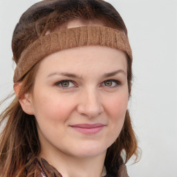 Joyful white young-adult female with long  brown hair and blue eyes