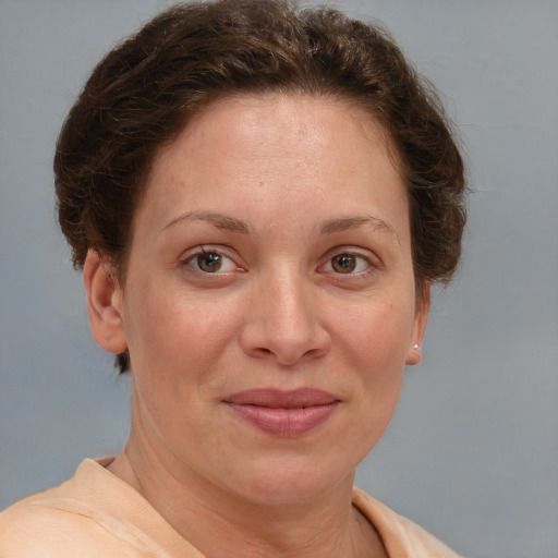 Joyful white adult female with short  brown hair and blue eyes