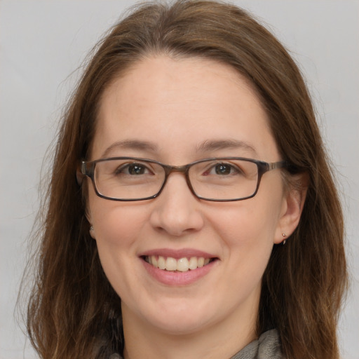 Joyful white adult female with long  brown hair and grey eyes