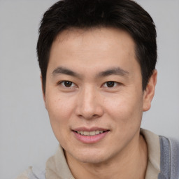 Joyful asian young-adult male with short  brown hair and brown eyes