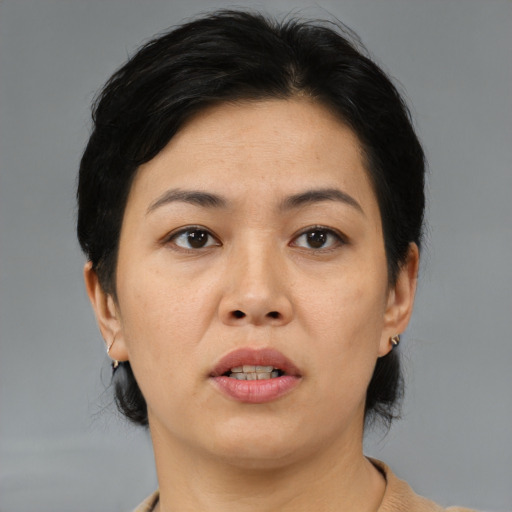 Joyful asian adult female with medium  black hair and brown eyes