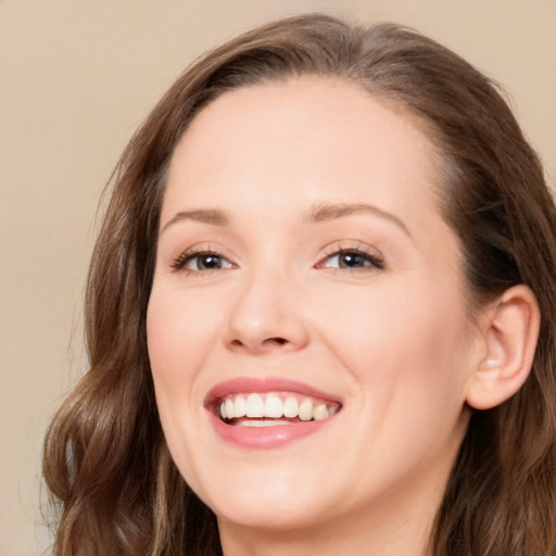 Joyful white young-adult female with long  brown hair and blue eyes