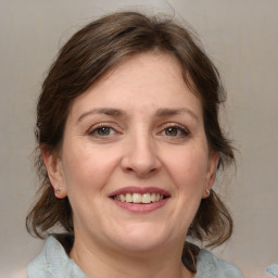 Joyful white adult female with medium  brown hair and grey eyes