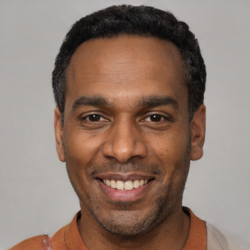 Joyful latino adult male with short  black hair and brown eyes