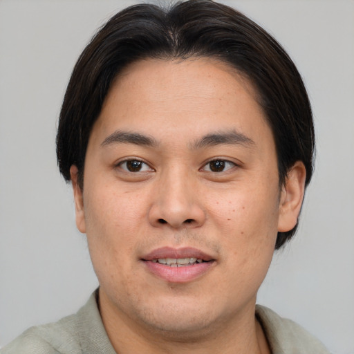 Joyful asian young-adult male with short  brown hair and brown eyes
