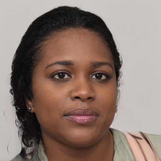 Joyful black young-adult female with medium  brown hair and brown eyes