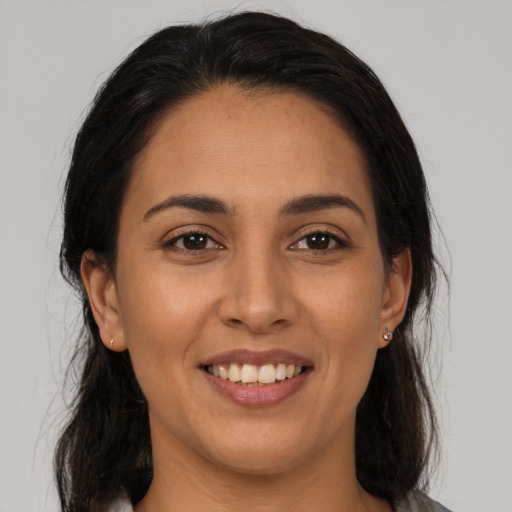 Joyful latino young-adult female with long  brown hair and brown eyes