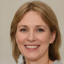 Joyful white adult female with medium  brown hair and blue eyes