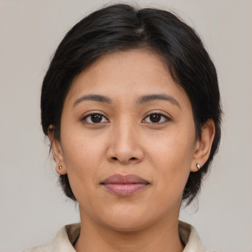 Joyful latino young-adult female with medium  brown hair and brown eyes