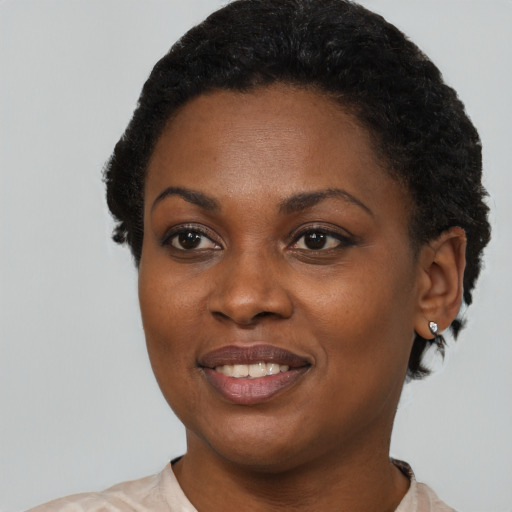 Joyful black young-adult female with short  brown hair and brown eyes
