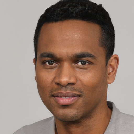 Joyful black young-adult male with short  black hair and brown eyes