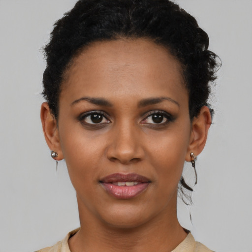 Joyful black young-adult female with short  black hair and brown eyes
