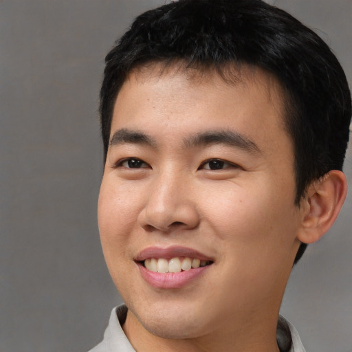 Joyful asian young-adult male with short  black hair and brown eyes
