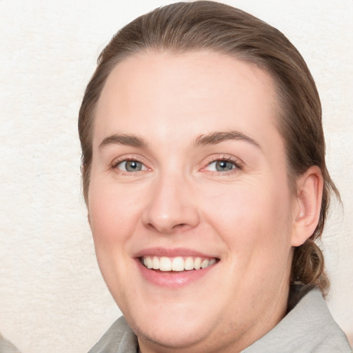 Joyful white young-adult female with medium  brown hair and blue eyes