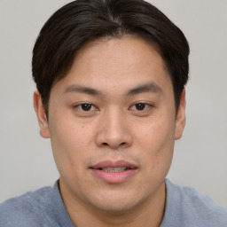 Joyful asian young-adult male with short  brown hair and brown eyes