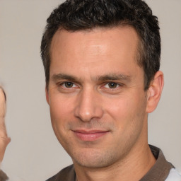 Joyful white adult male with short  brown hair and brown eyes