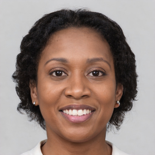 Joyful black young-adult female with medium  brown hair and brown eyes