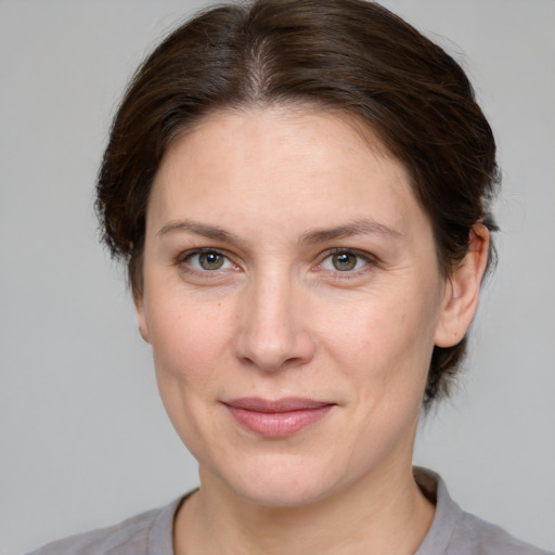 Joyful white adult female with medium  brown hair and grey eyes