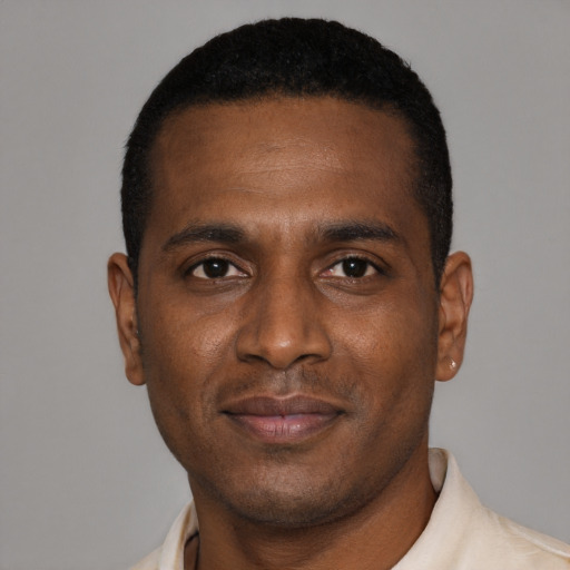 Joyful black young-adult male with short  brown hair and brown eyes