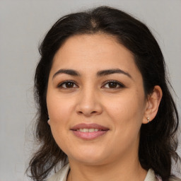 Joyful latino young-adult female with medium  brown hair and brown eyes