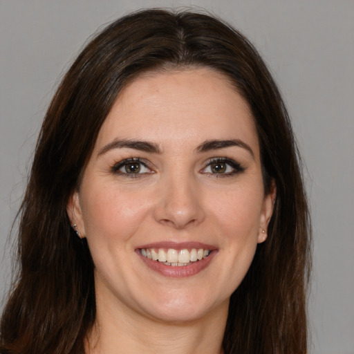 Joyful white young-adult female with long  brown hair and brown eyes