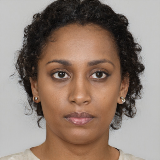 Neutral black young-adult female with medium  brown hair and brown eyes