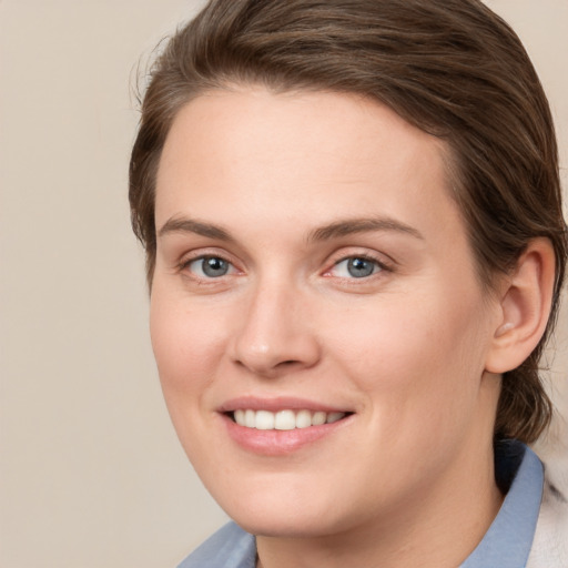 Joyful white young-adult female with medium  brown hair and grey eyes