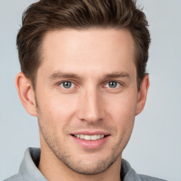 Joyful white young-adult male with short  brown hair and grey eyes