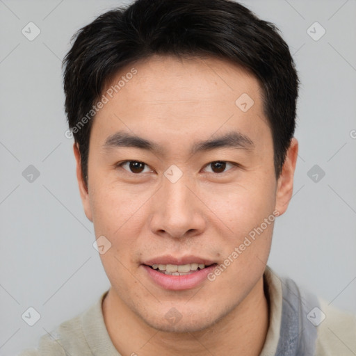 Joyful asian young-adult male with short  brown hair and brown eyes