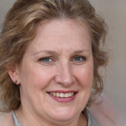 Joyful white adult female with medium  brown hair and blue eyes