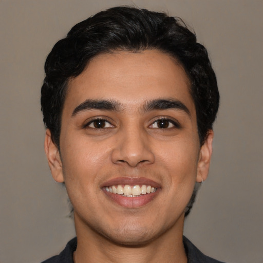 Joyful latino young-adult male with short  black hair and brown eyes