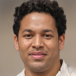 Joyful latino young-adult male with short  brown hair and brown eyes