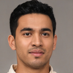 Joyful latino young-adult male with short  brown hair and brown eyes