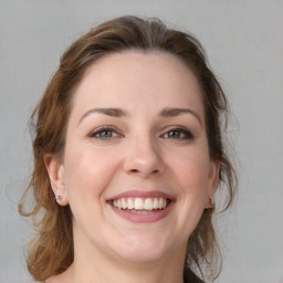 Joyful white young-adult female with medium  brown hair and grey eyes