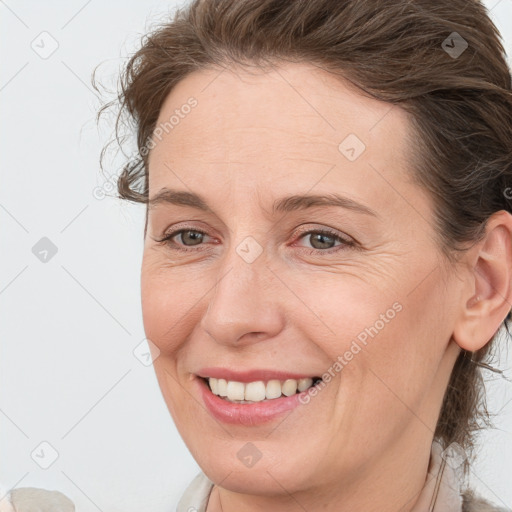 Joyful white adult female with medium  brown hair and grey eyes