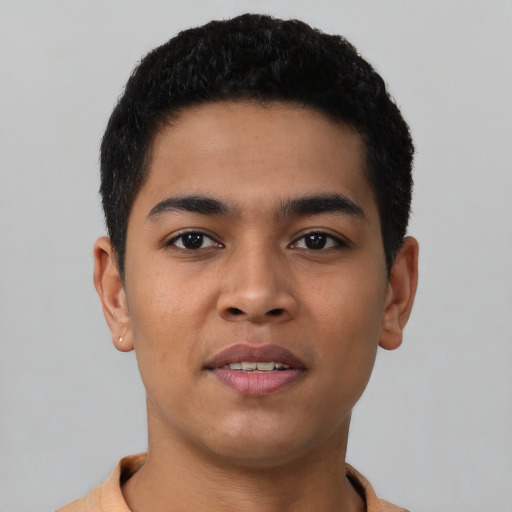 Joyful latino young-adult male with short  brown hair and brown eyes