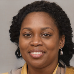 Joyful black adult female with long  brown hair and brown eyes