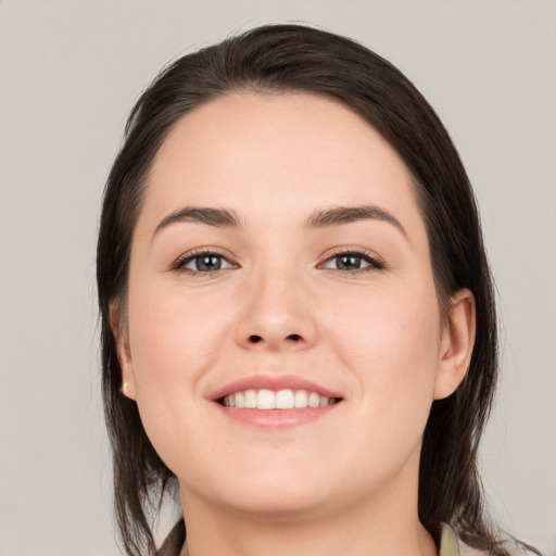 Joyful white young-adult female with long  brown hair and brown eyes