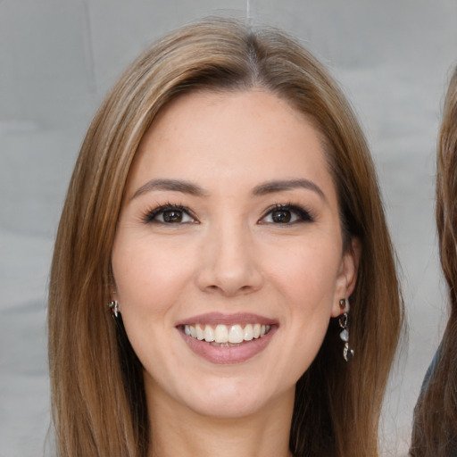 Joyful white young-adult female with long  brown hair and brown eyes