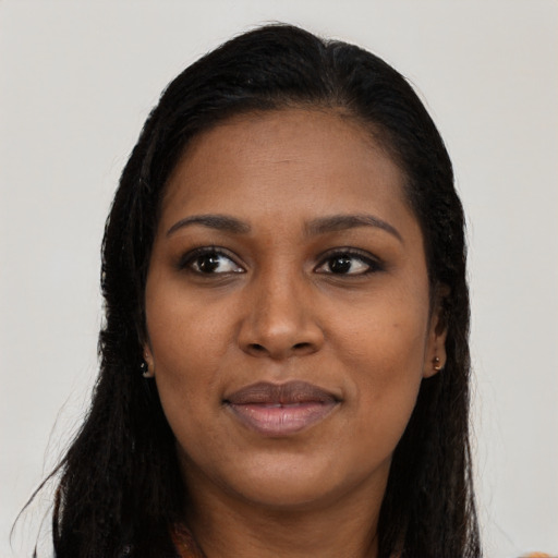 Joyful black young-adult female with long  brown hair and brown eyes
