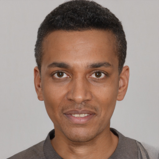 Joyful black young-adult male with short  black hair and brown eyes