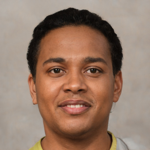 Joyful latino young-adult male with short  black hair and brown eyes