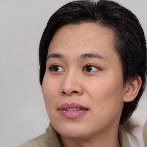 Joyful asian young-adult female with medium  brown hair and brown eyes